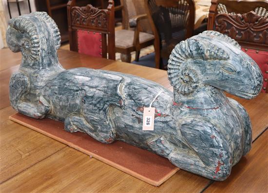 An Eastern painted carved wood double headed ram
